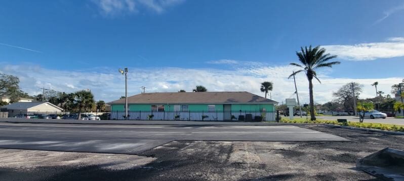 Commercial parking lot with a damaged section removed and patched in front of a building